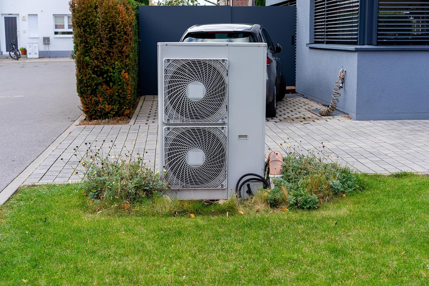 Air heat pump placed in the garden of a residential area