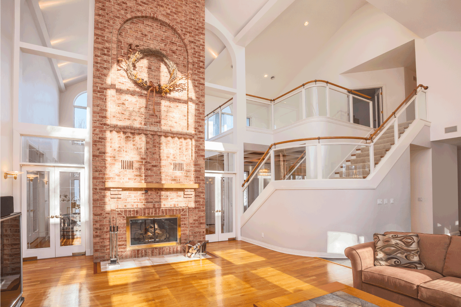 Amazing home interior architecture, cathedral ceiling with brick fireplace and spectacular glass staircase