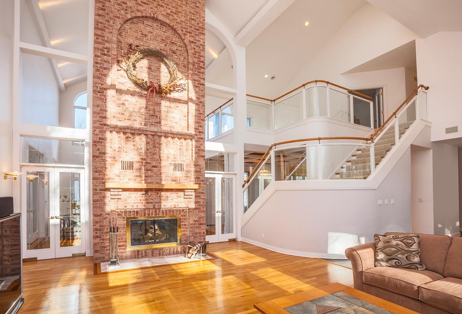 Amazing home interior with brick fireplace and spectacular glass staircase