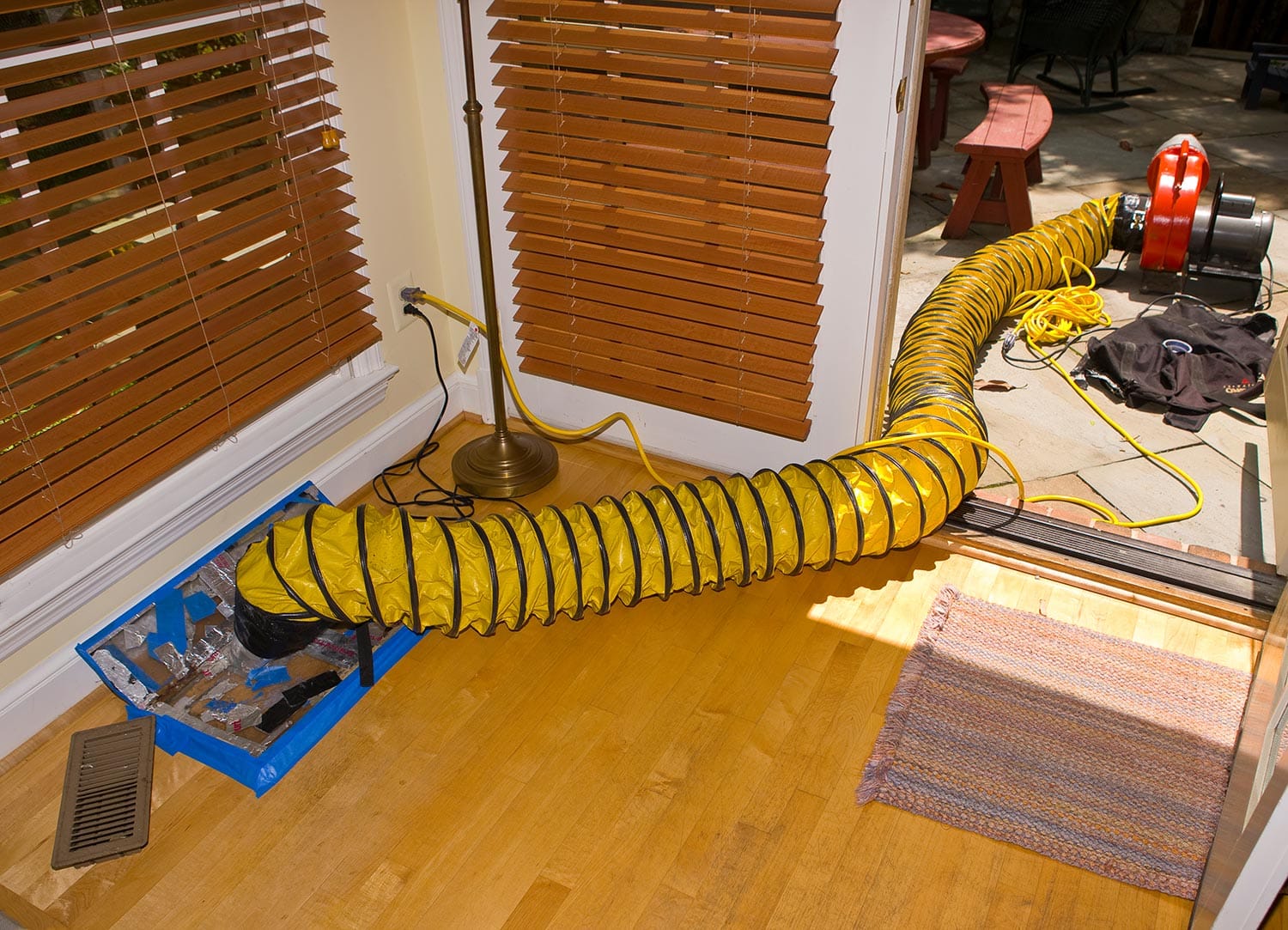 Blower attached to floor vent during duct cleaning in home