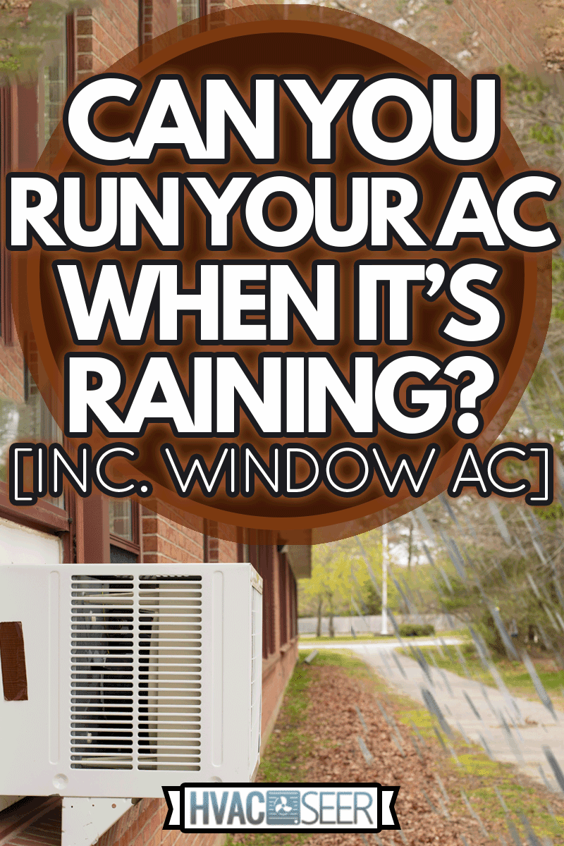 Window air conditioner unit in window in brick building with green grass and leaves on ground, Can You Run Your AC When It's Raining? [Inc. Window AC]