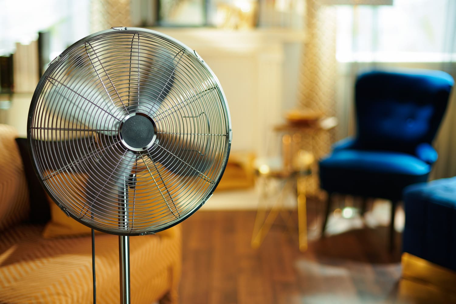 Closeup on working electric floor standing fan in the modern house in sunny hot summer day.
