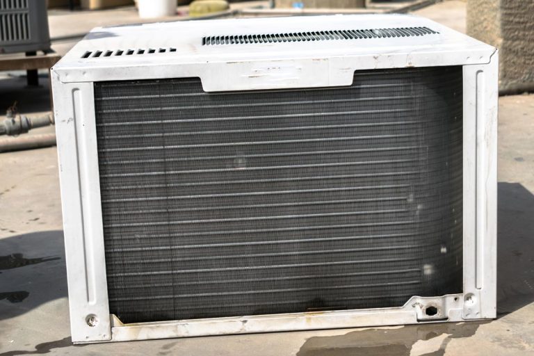 Dusty and dirty air conditioning cooling system is being cleaning by a professional electrician, Can You Store A Window AC On Its Side?