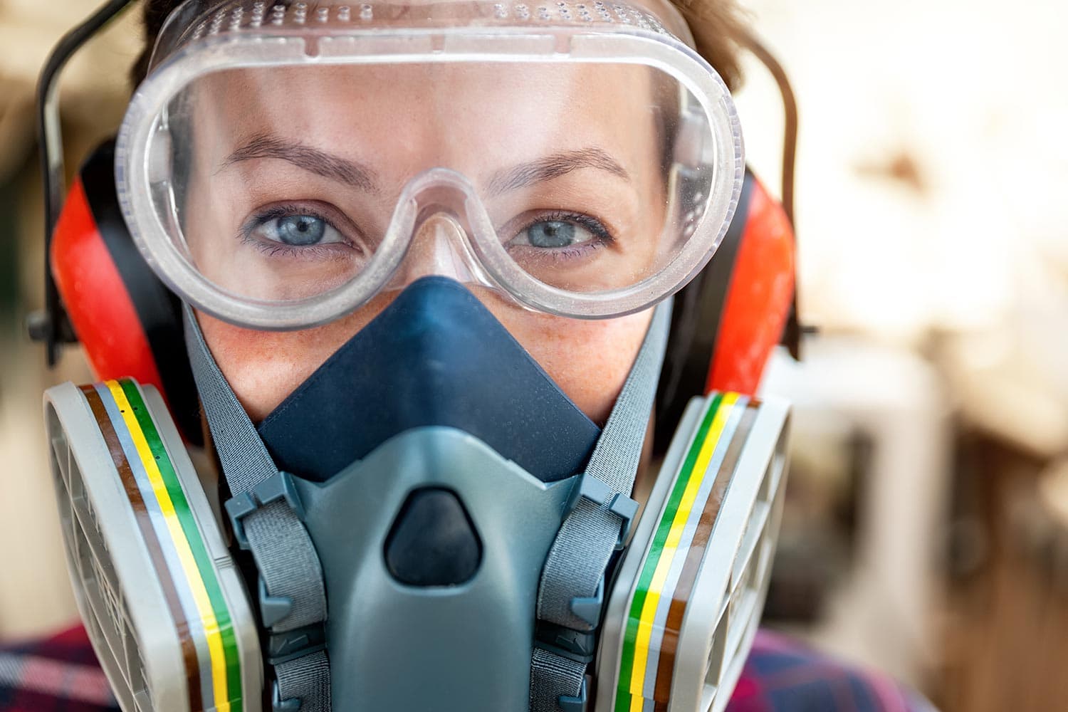 Female carpenter wearing ppe respirator goggles and ear protection