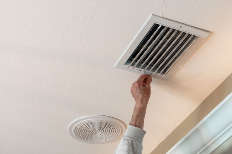 Handyman adjusting HVAC ceiling air vent, How Strong Should Air Come Out of Vents?