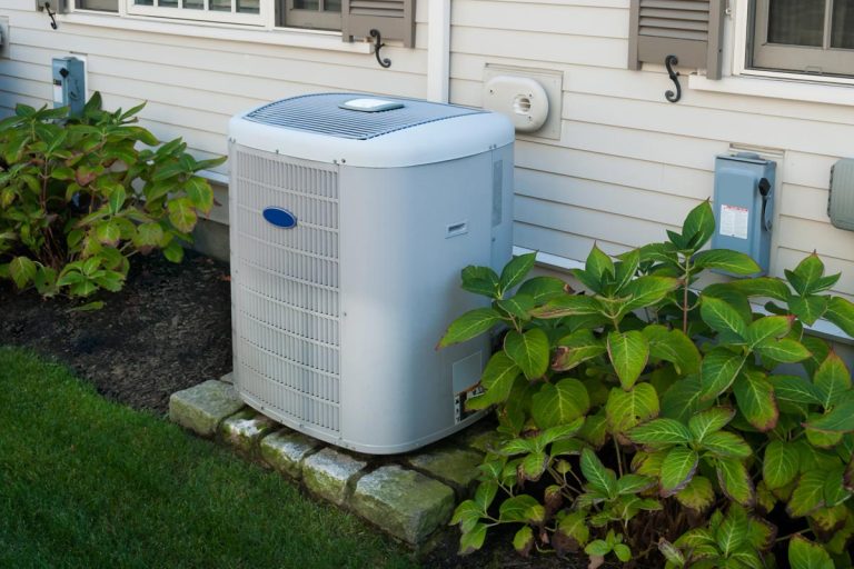 A heating and air conditioning inverter on the side of a house, How Much Does An Air Conditioner Weigh?
