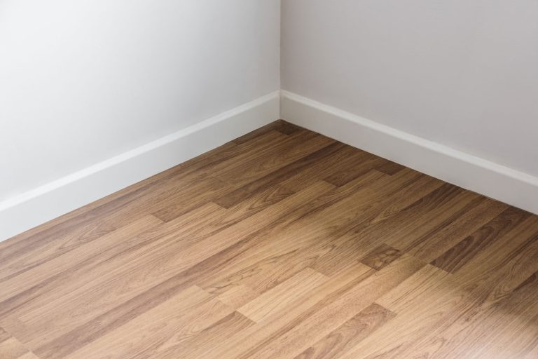 Laminated flooring inside a white themed living room, Do I Need Insulation Between Floors? [Pros and Cons]
