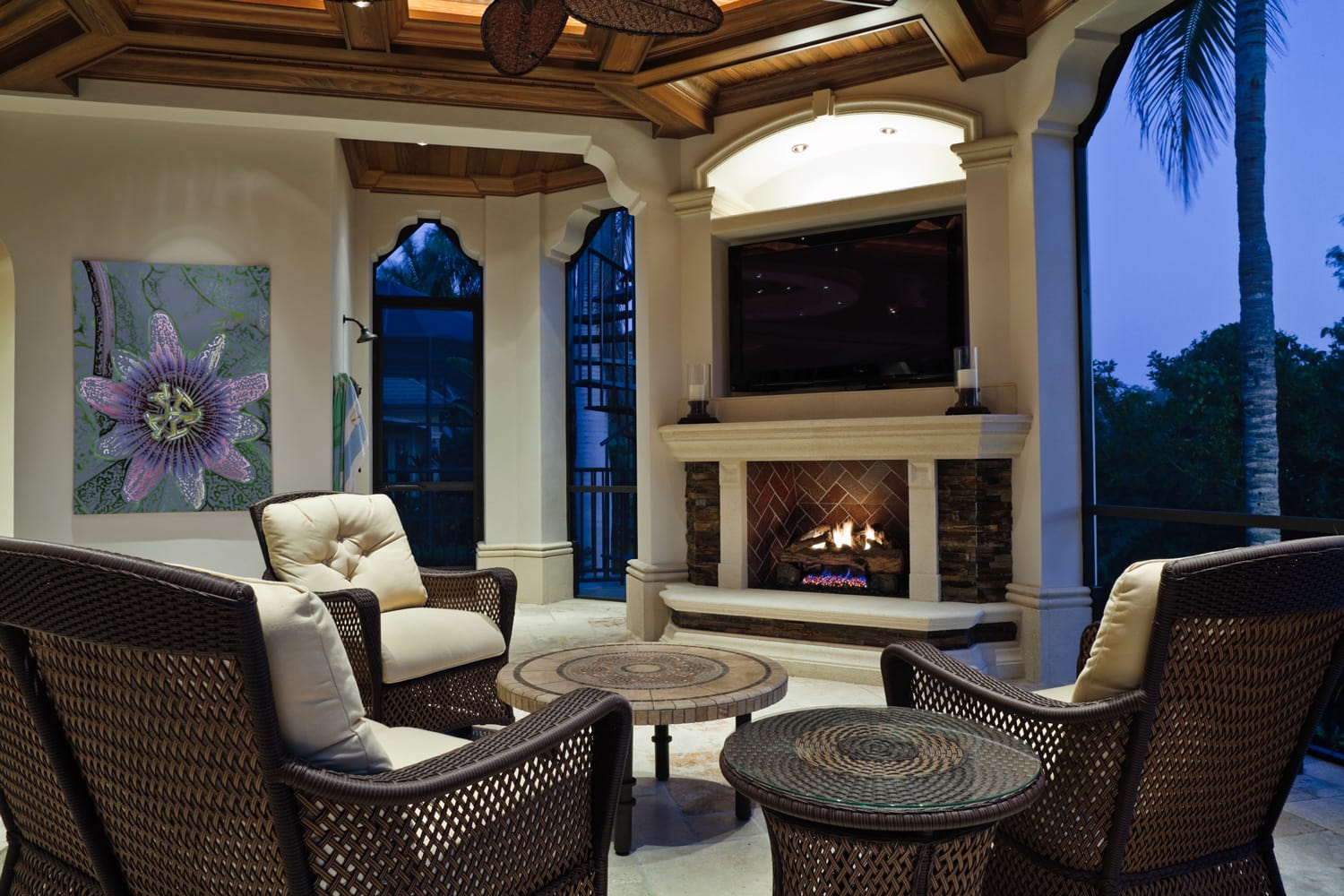 Outdoor sitting area with fireplace in a tropical setting at an estate home.