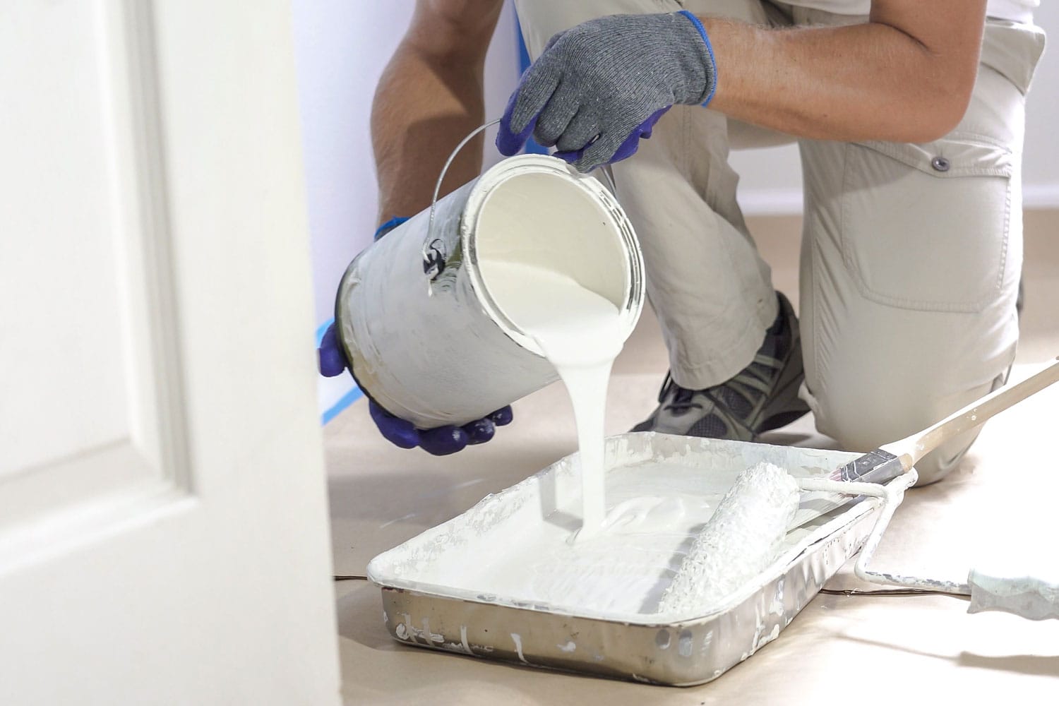 Painter pouring white paint