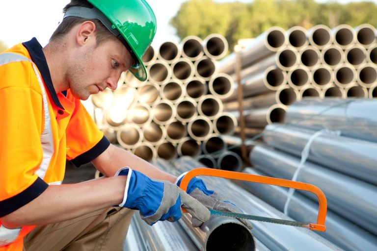A pipefitter at work with pvc pipes, How Much Does A Pipefitter Make? [An In-Depth Salary Review]