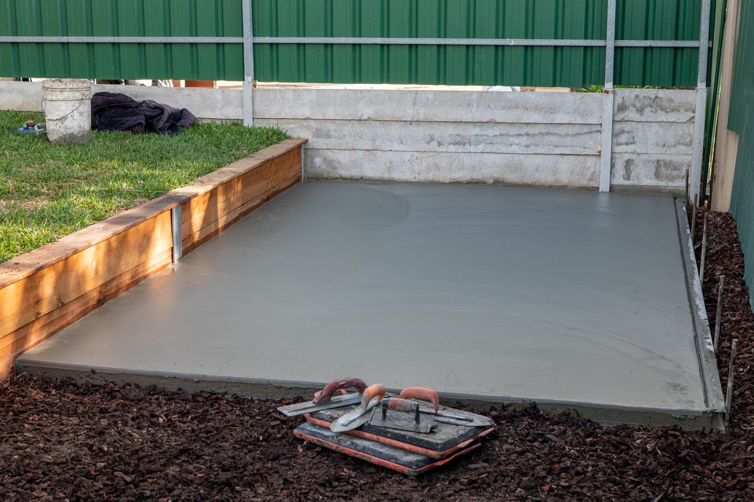 Pouring concrete slab for shed foundation in backyard