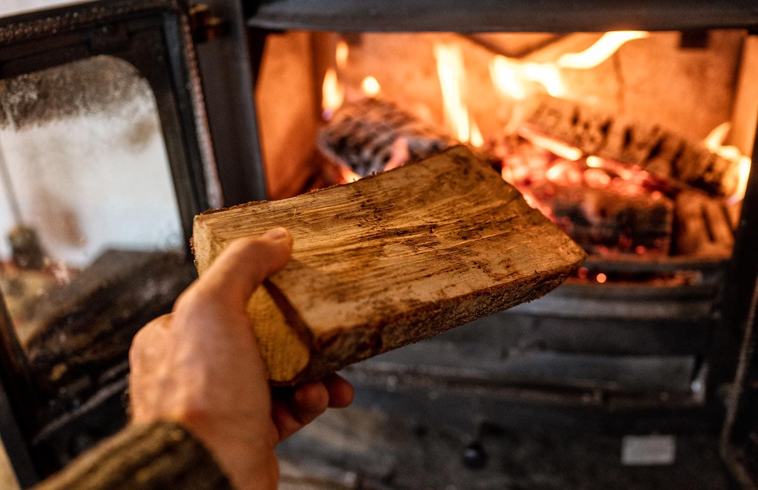 Putting a log into a wood burning stove