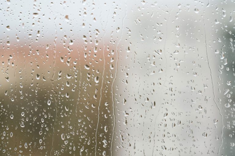Raindrops on a window pane during rainy weather, Does Rain Cause Humidity? [Indoors & Out]