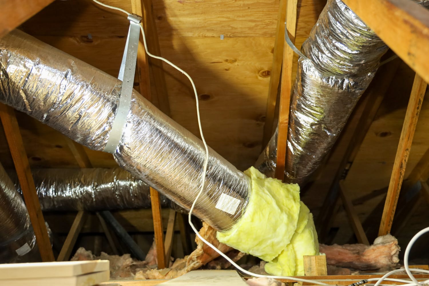 View of fiber glass duct for central air in an attic.