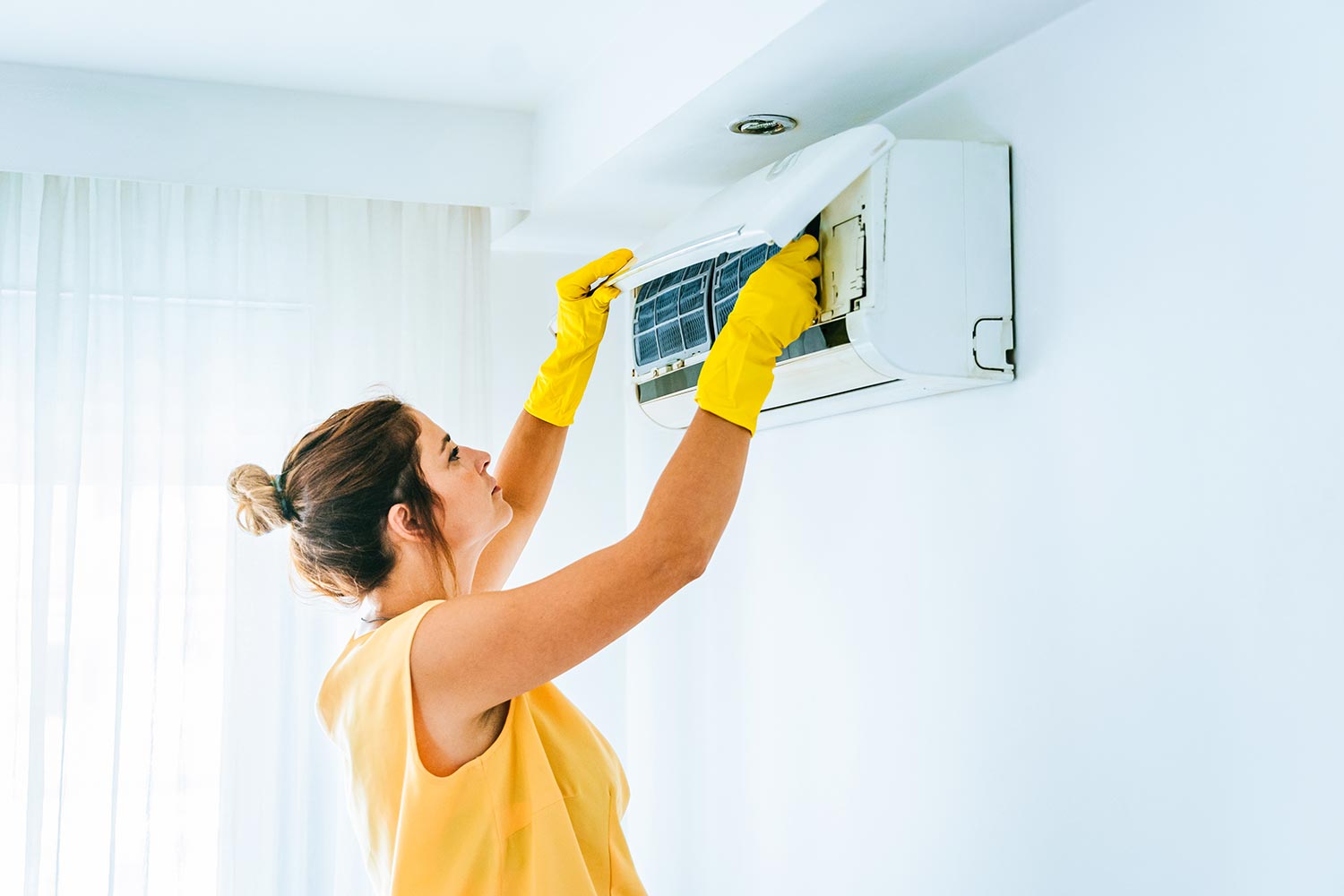 Woman cleaning air conditioning system