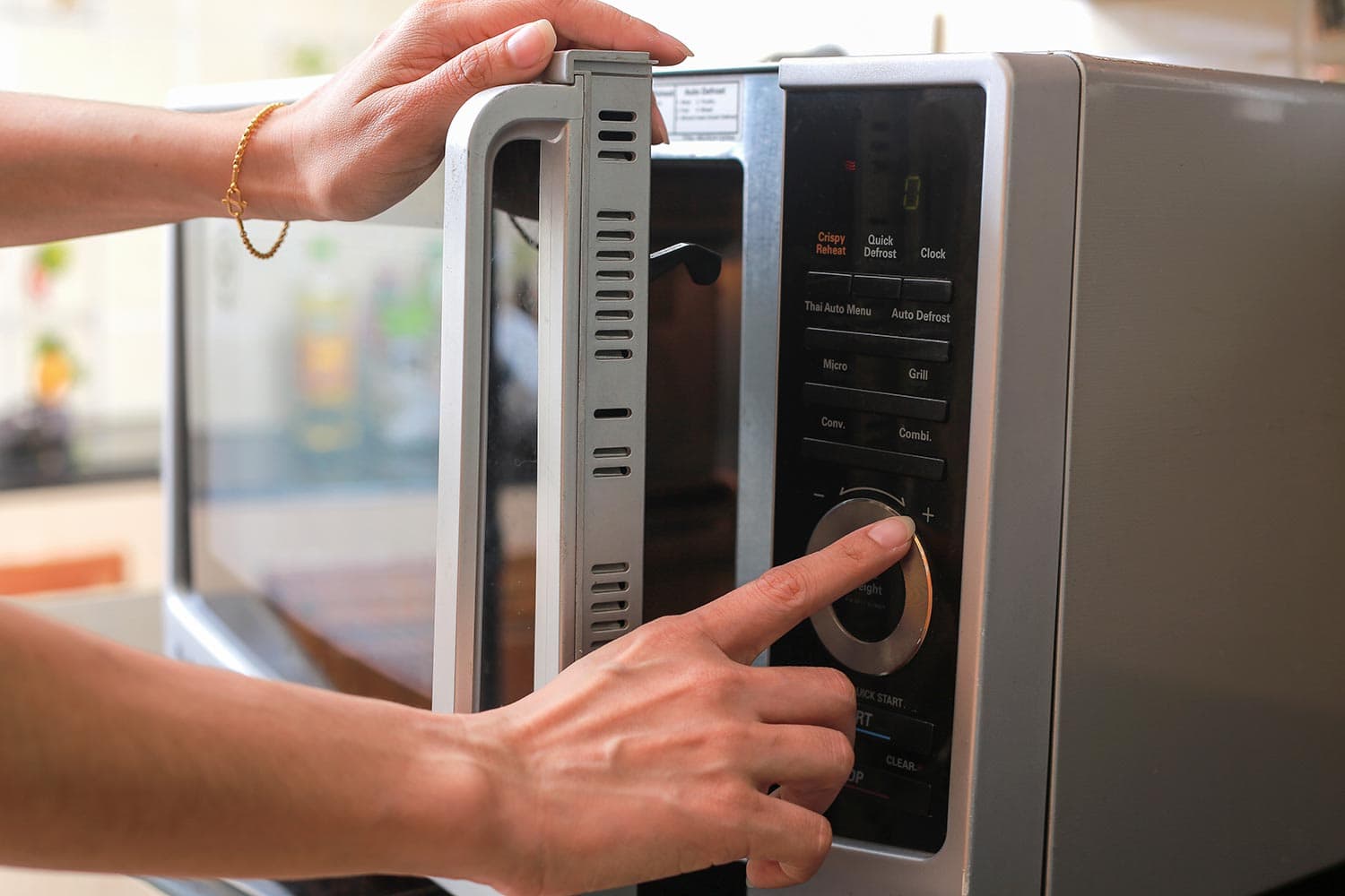 Woman closing microwave oven door