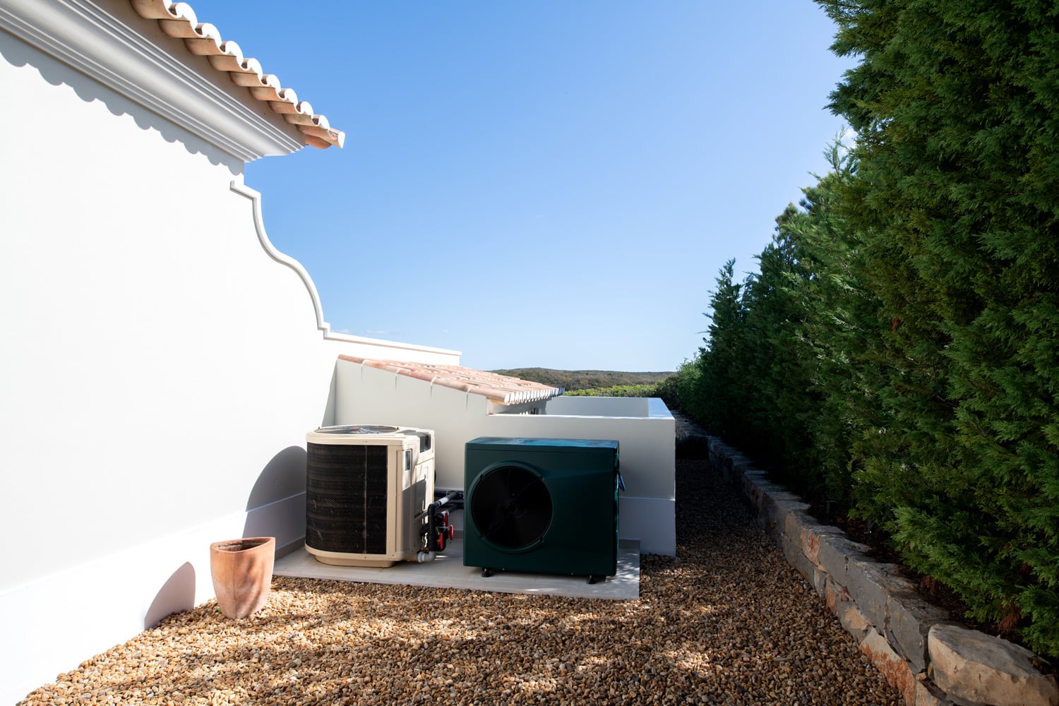 two pool heaters, one old and one new situated at the back of a house