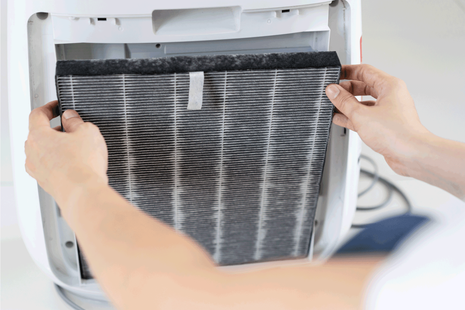 woman changing the dirty air purifier filter after using for a long time in the dirty air environment