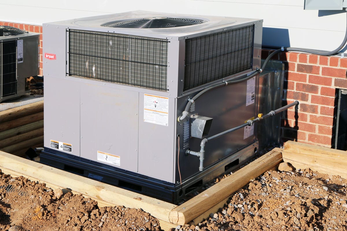 A Bryant air conditioning unit mounted on a concrete block