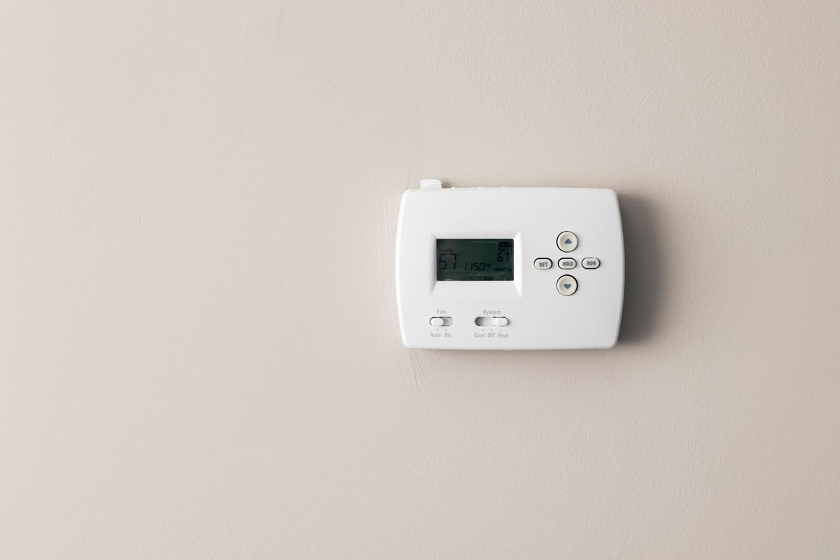 A Digital White thermostat on a wall
