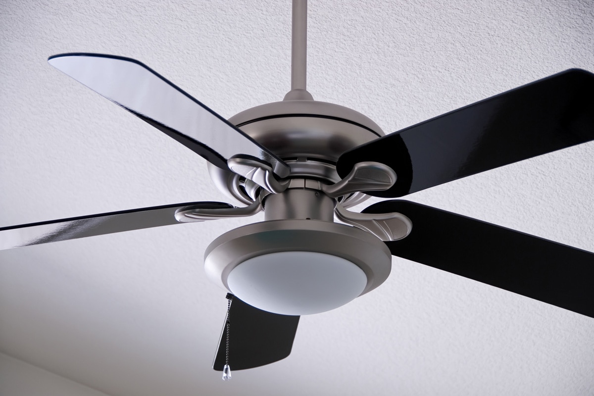 A brushed metal ceiling fan with black fins.