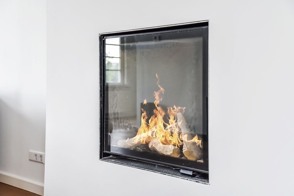 A glass walled fireplace painted in white