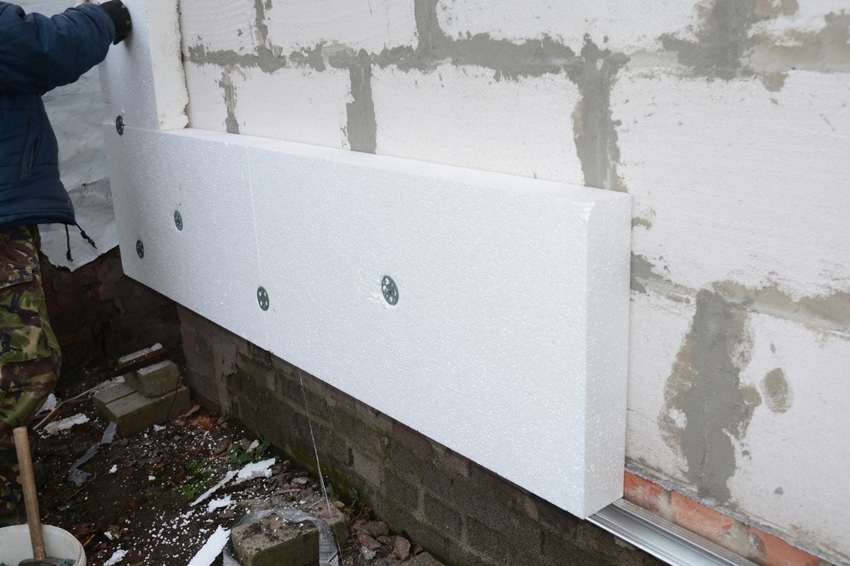Building contractor insulating House Wall with styrofoam insulation sheets