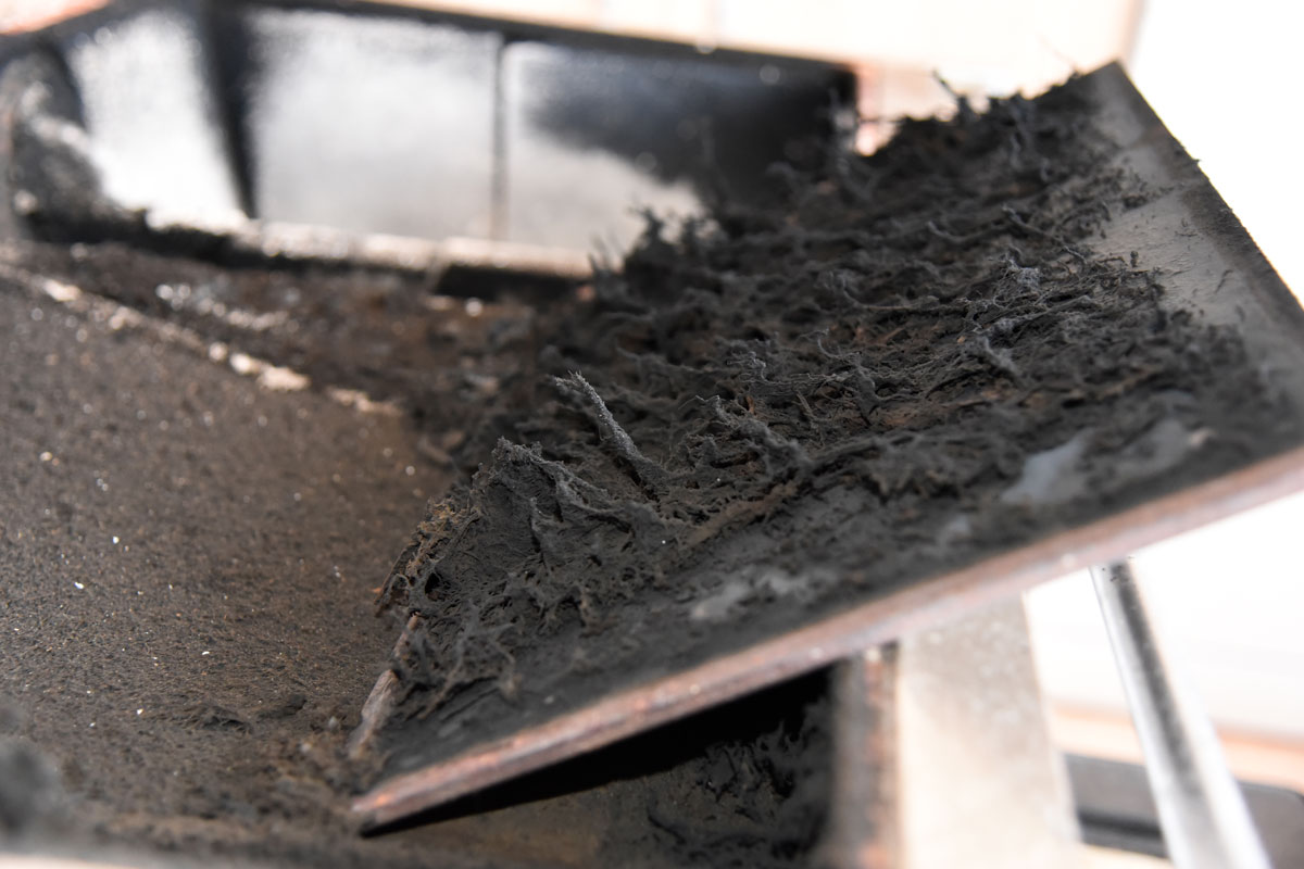 Burnt fibers accumulating on the side panels of a fireplace