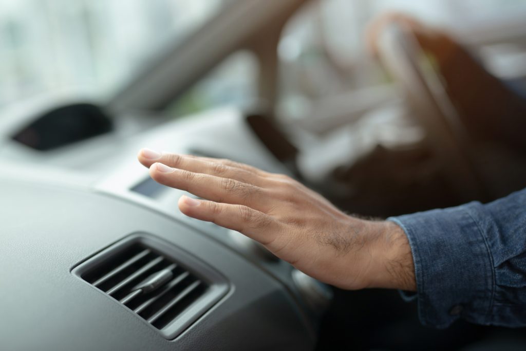 Closeup of hand driver man checking adjusting air from conditioning the cooling system with flow of cold air in car. Leave space for writing text.
