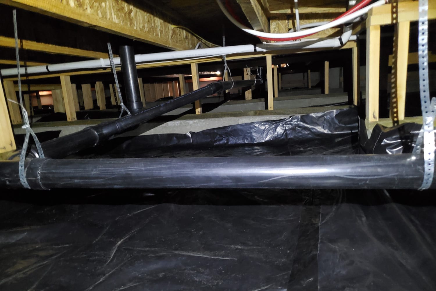 Crawlspace under a residential building with new vapor barrier.