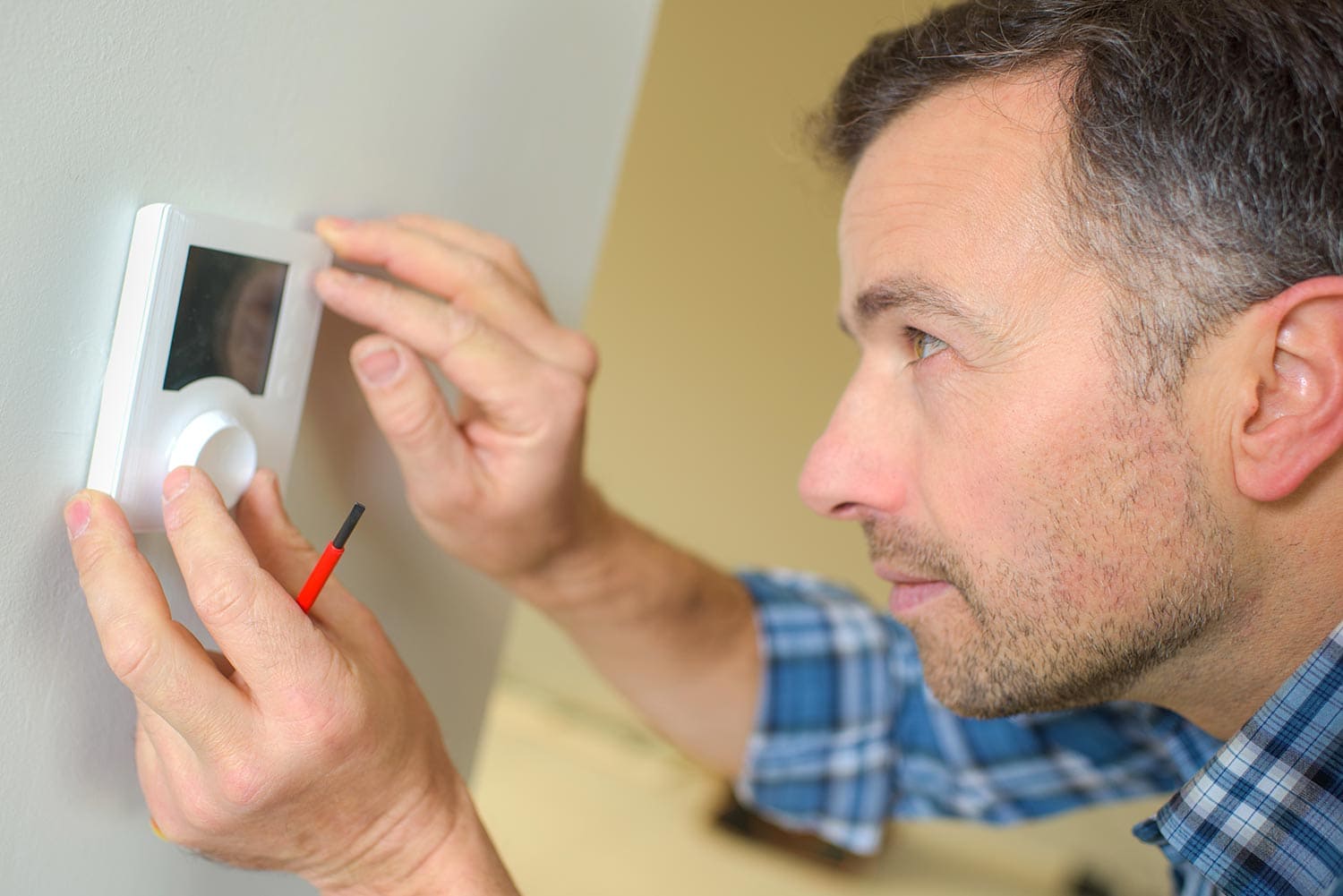 Electrician fitting a thermostat system