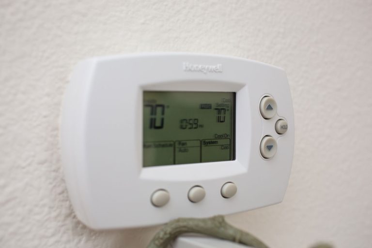 Honeywell thermostat mounted on a white wall, How To Turn Off Permanent Hold On Honeywell Thermostat