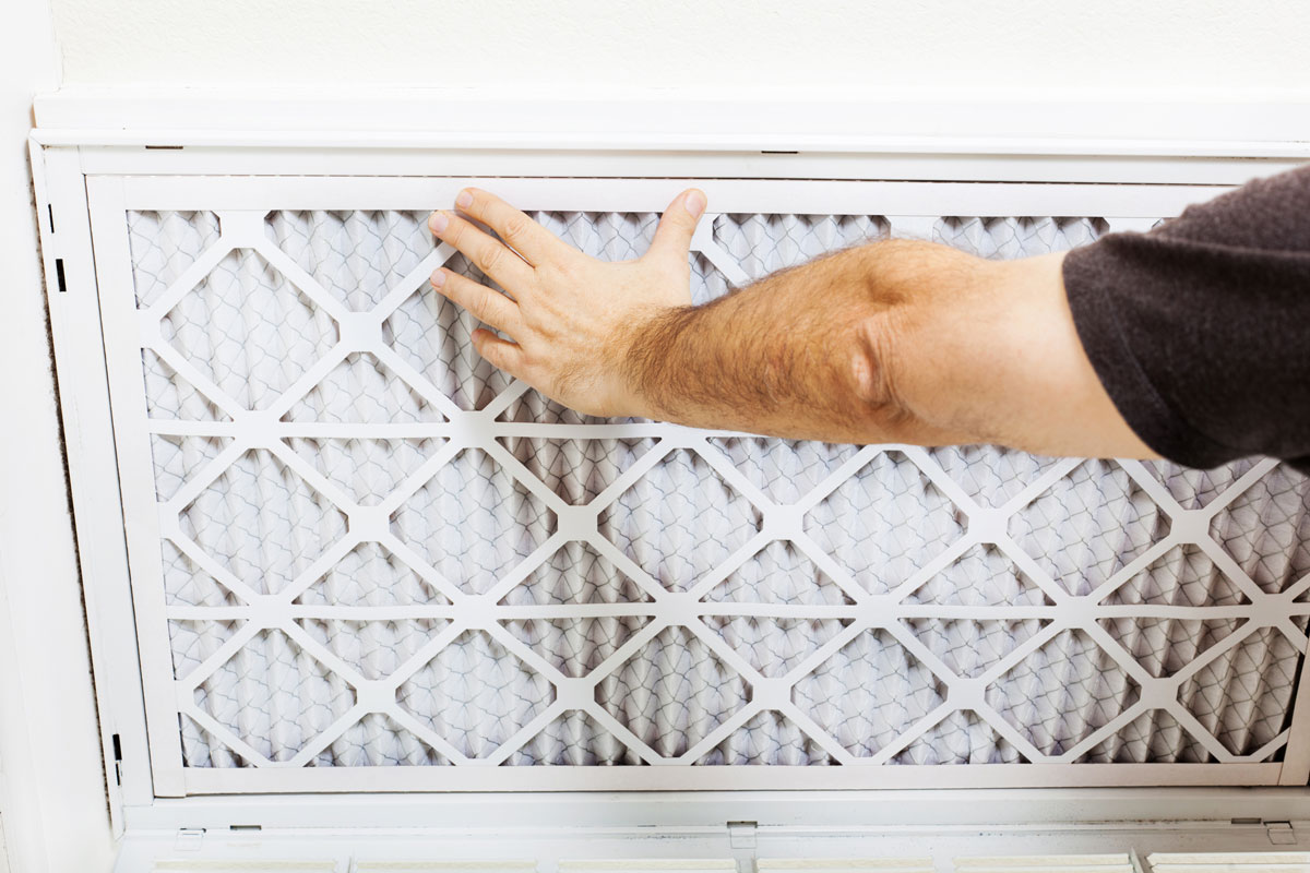 Man replacing AC filter for a home air conditioning system