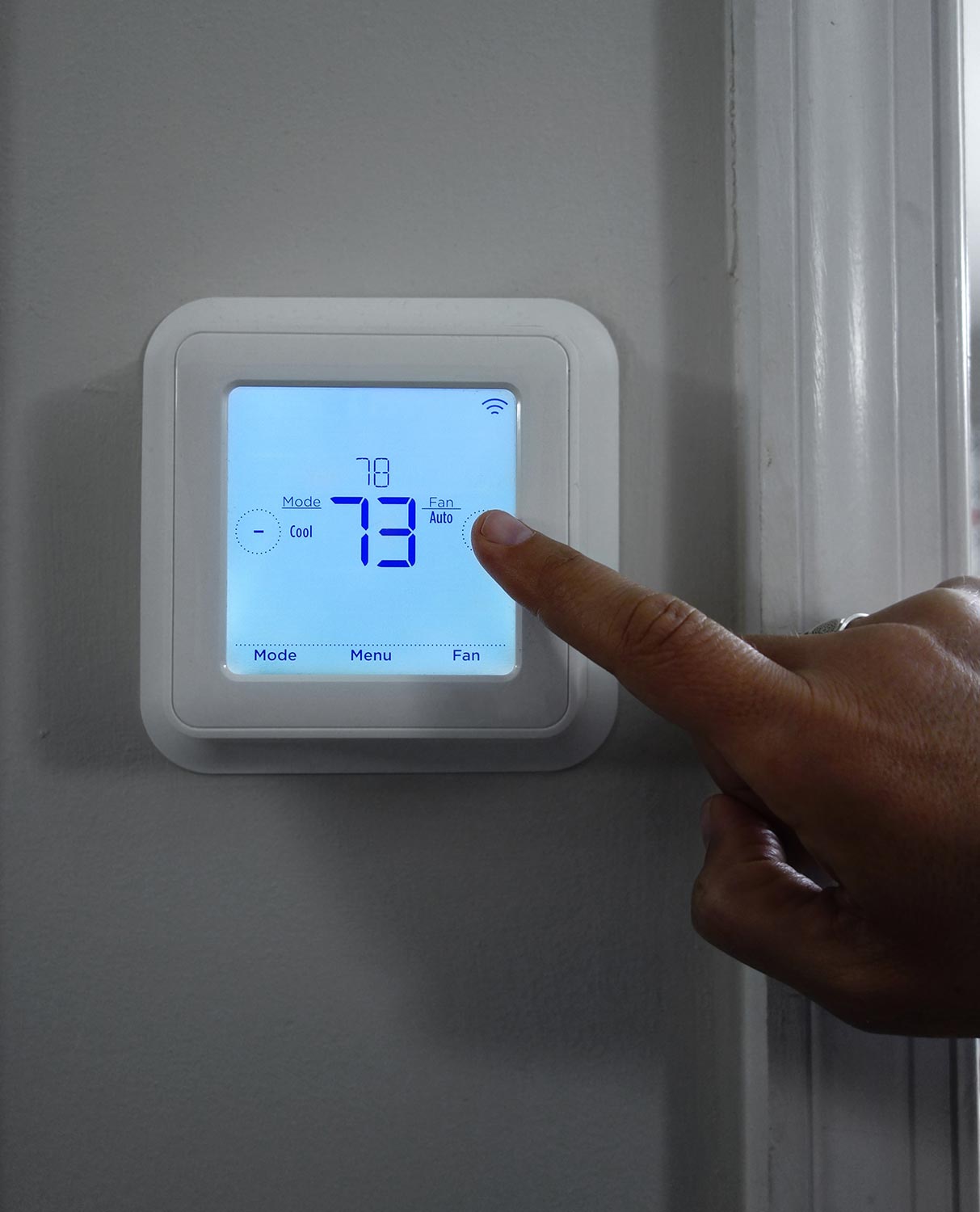 Person adjusting the home temperature on a smart thermostat