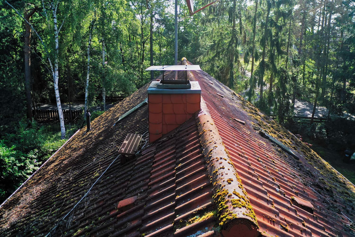 Pictures of the inspection and control of the chimney and the roof of a single family house with a drone, aerial photograph