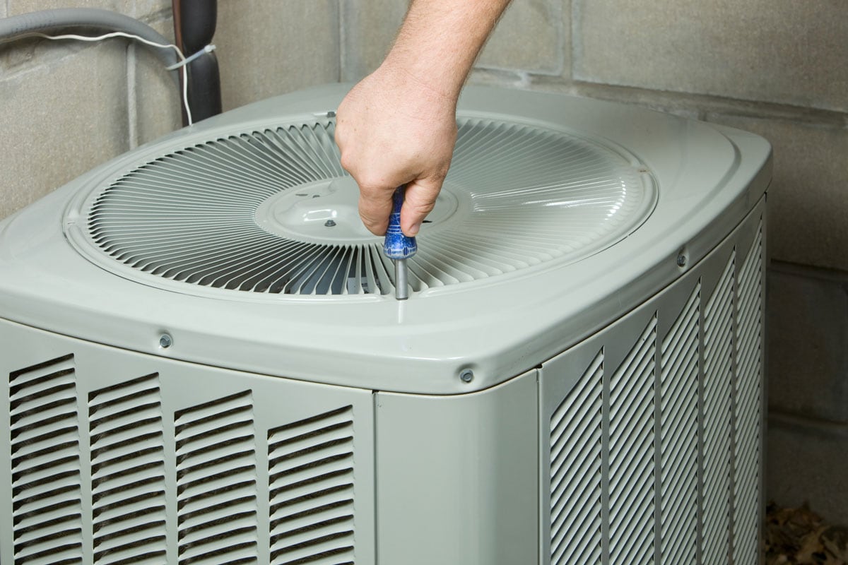 Service Technician Removing or Installing Air Conditioner Fan Cover