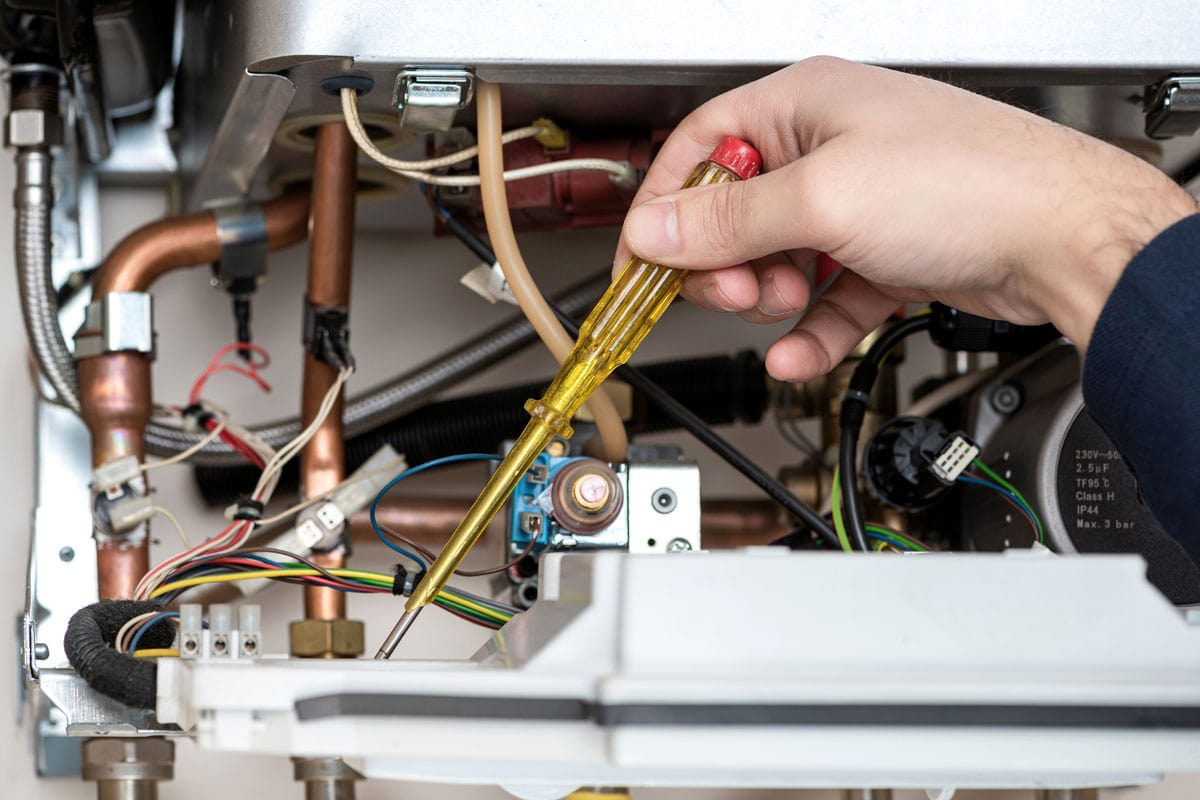 Technician repair maintenance on a furnace while check circuit using a flatscrew