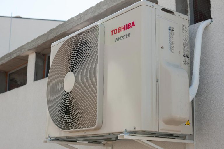 A toshiba air conditioner outdoor unit installed on the wall, How To Clean A Toshiba Air Conditioner [In 4 Easy Steps]
