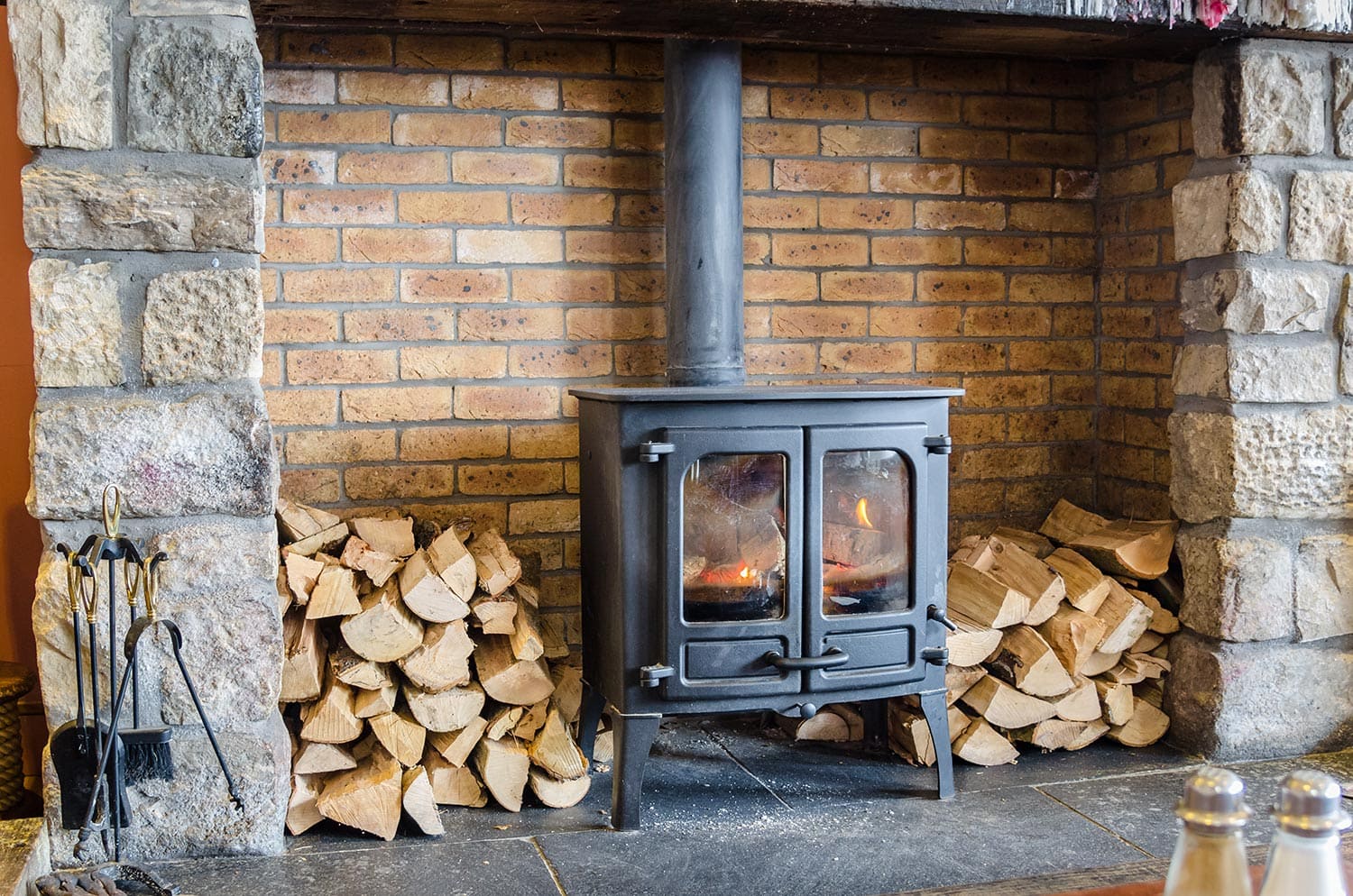 Tradional wood burning stove in a brick fireplace