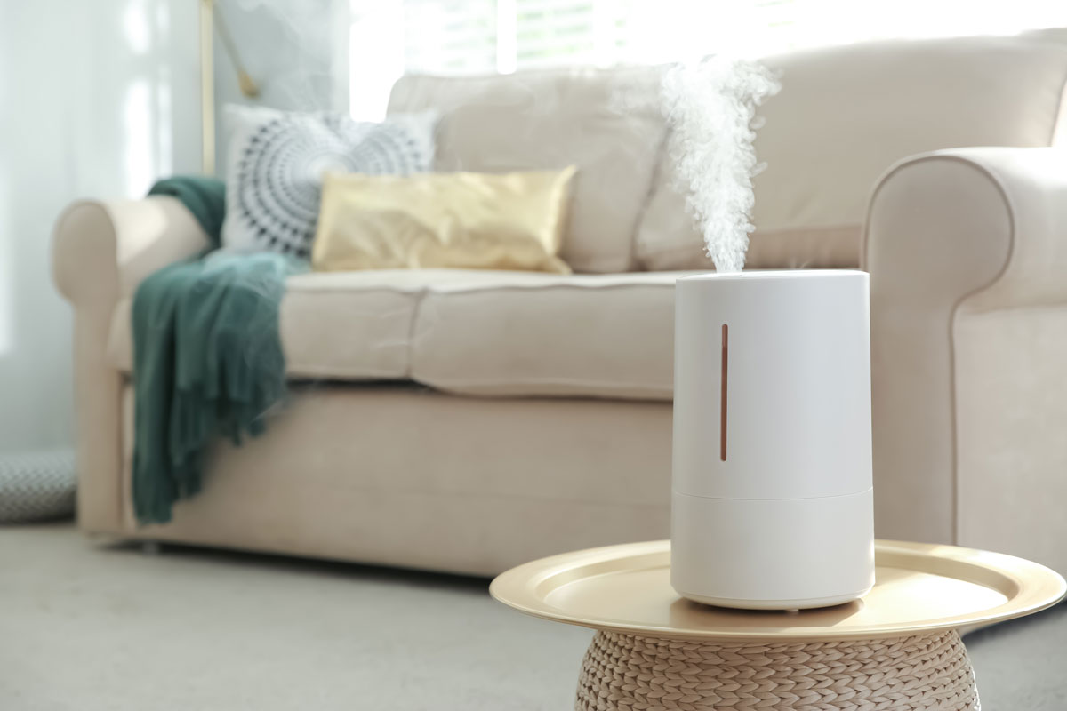 White humidifier on top of a wooden table inside the living room