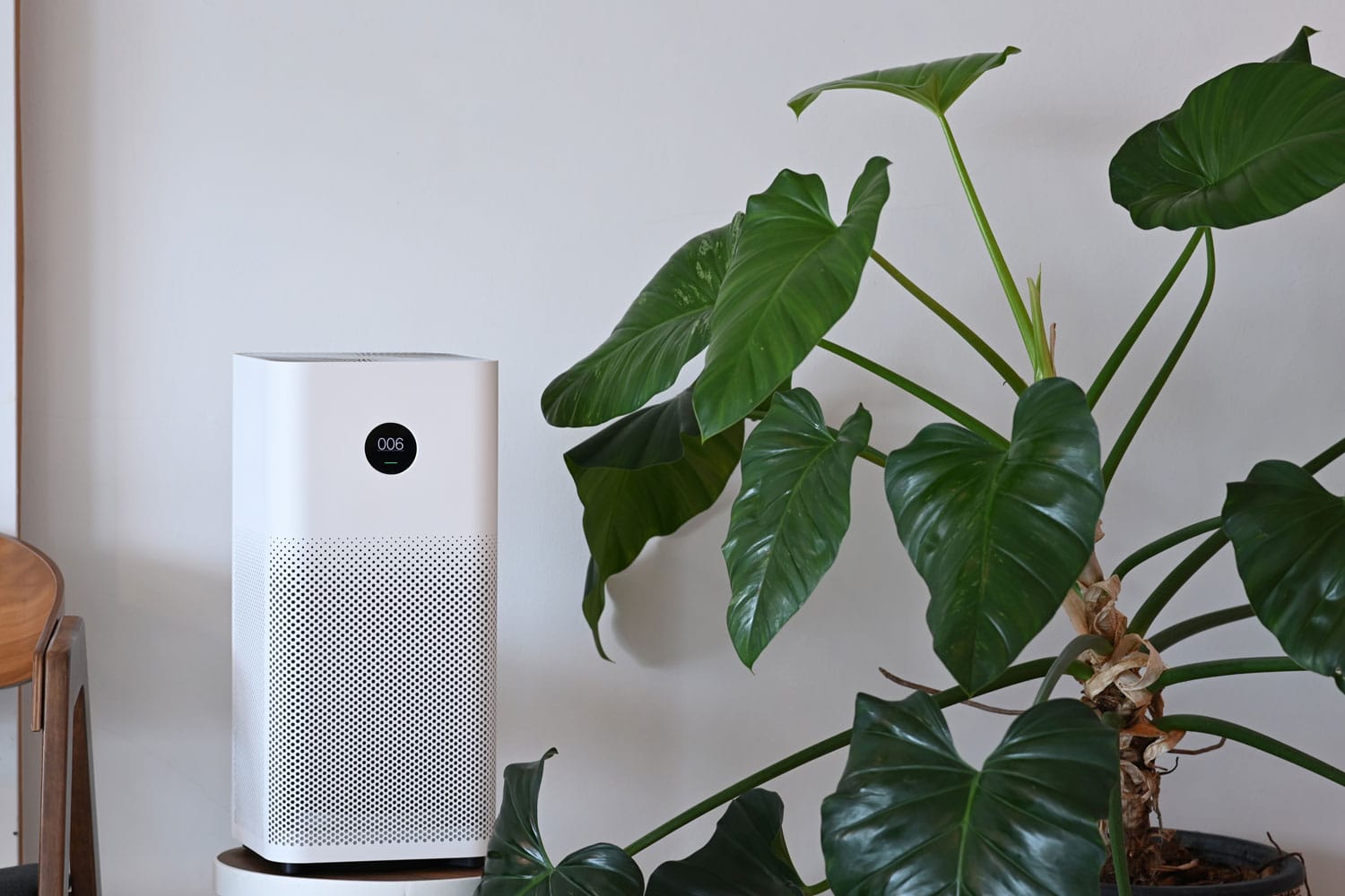 White tower air purifier placed on the corner of the living room