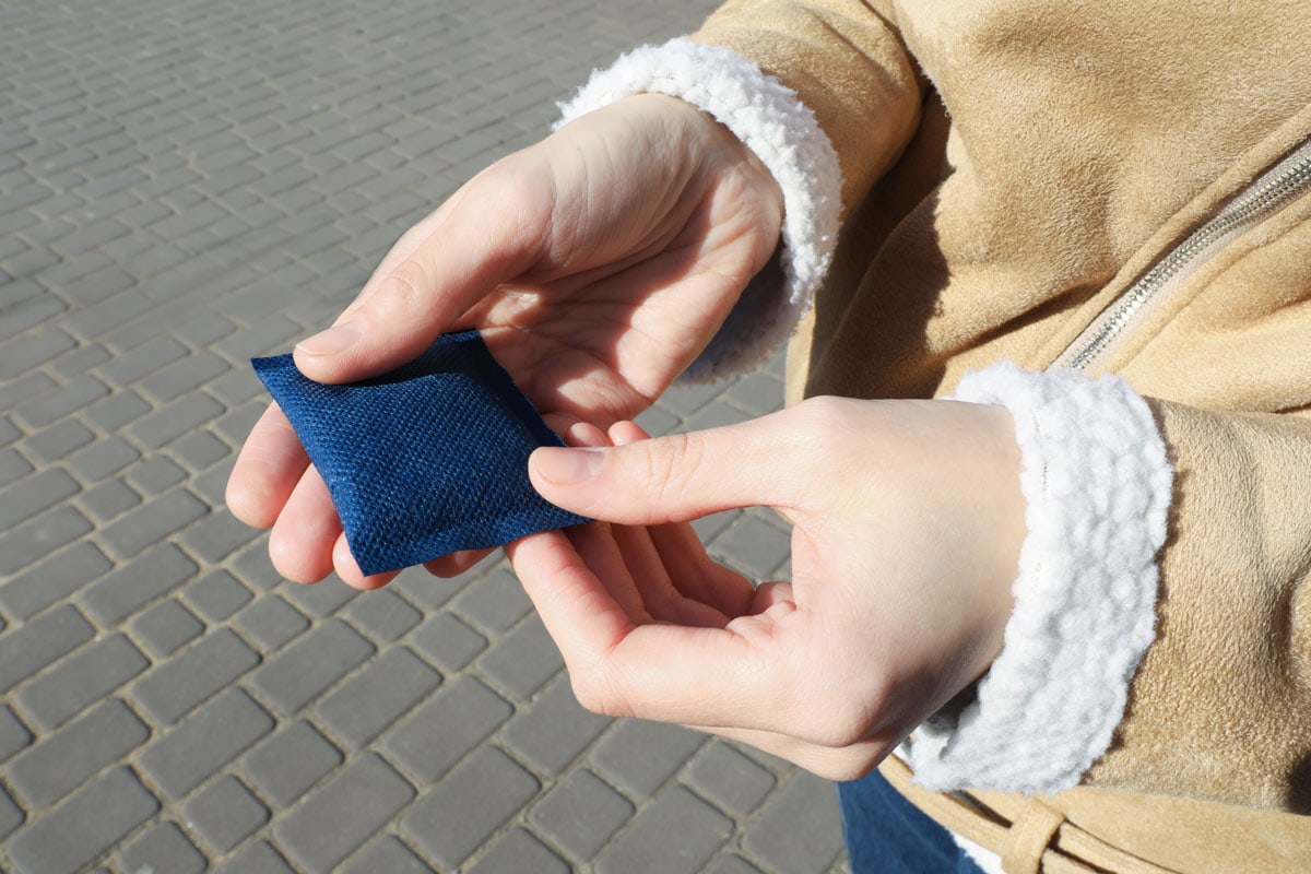 Woman holding a blue colored hand warmer