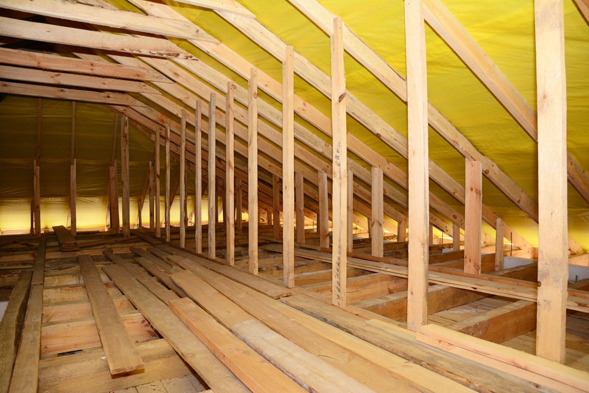 Wooden framing of an attic with yellow membrane for the roofing
