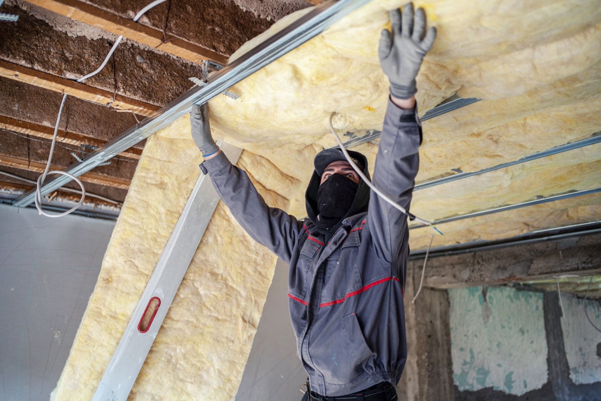 Worker installing insulation in the bathroom ceiling