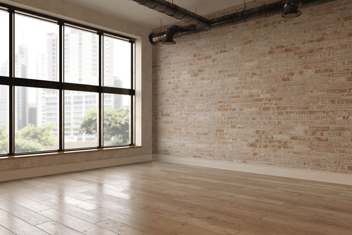 empty room with wooden brown floor and large glass window. How Many BTU For 12X12 Room [Everything You Need To Know]