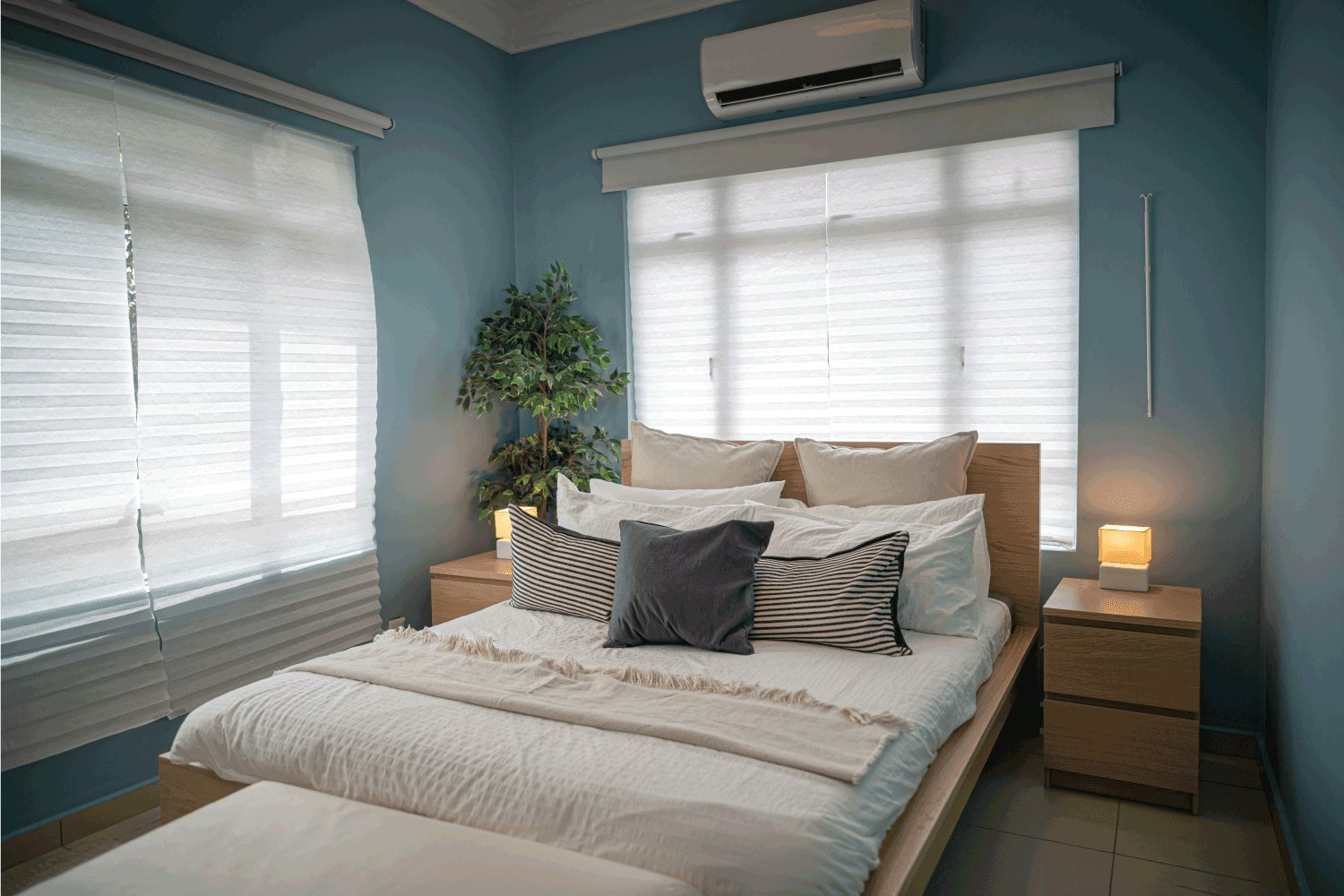 interior of a bungalow house bed room in day time without people, split type air conditioner above the window