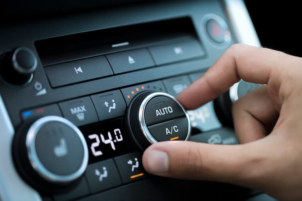 man hand turning on car air conditioning system