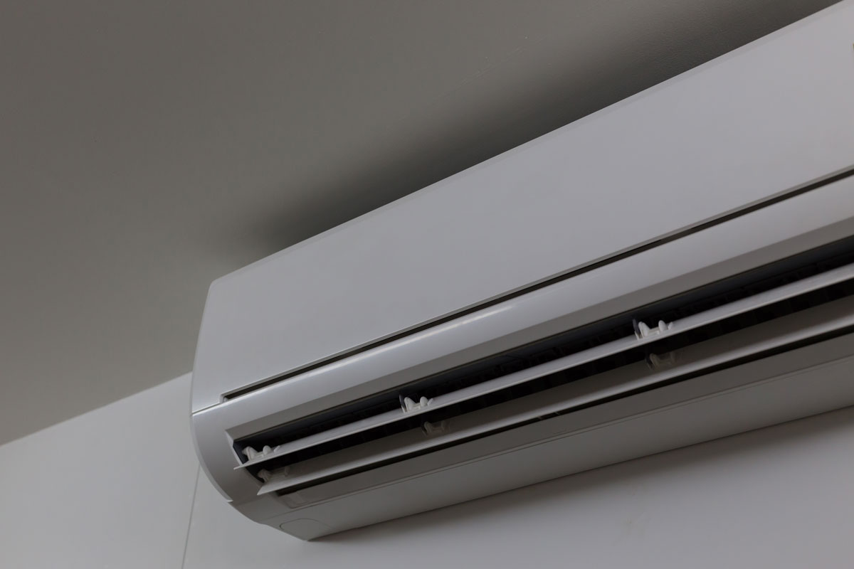 A mini split air conditioner mounted on a gray wall