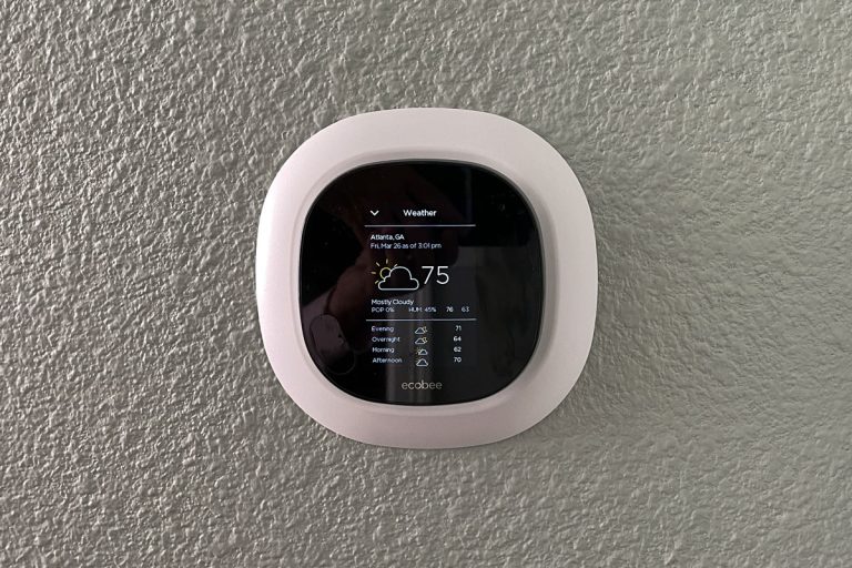 An Ecobee thermostat mounted in the living room wall, Do Ecobee Thermostats Talk To Each Other?