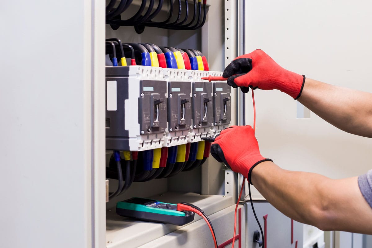 An electrical engineer checks the factory's electrical control cabinet
